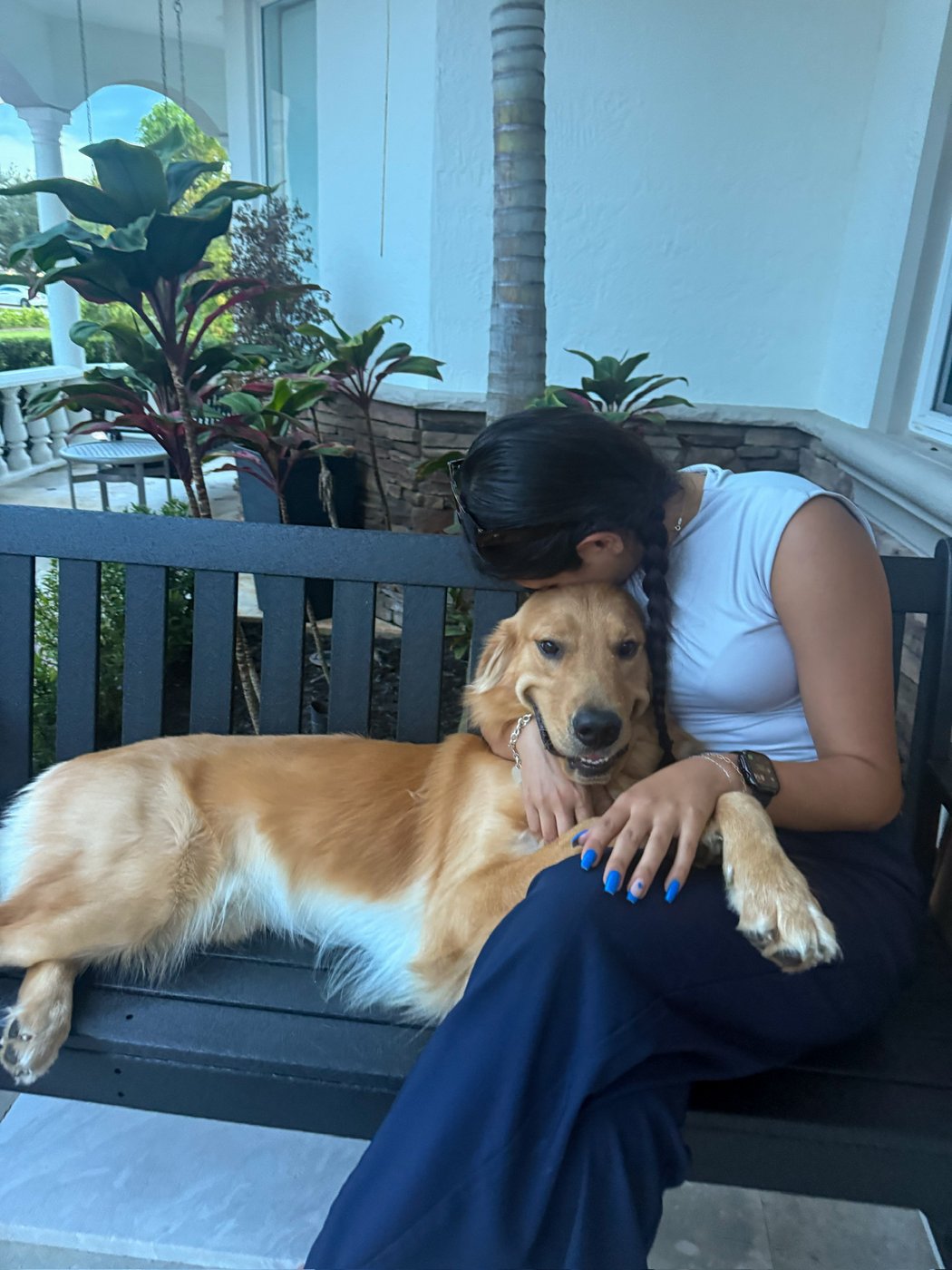 Isabella sharing a cuddle with a golden retriever on a porch